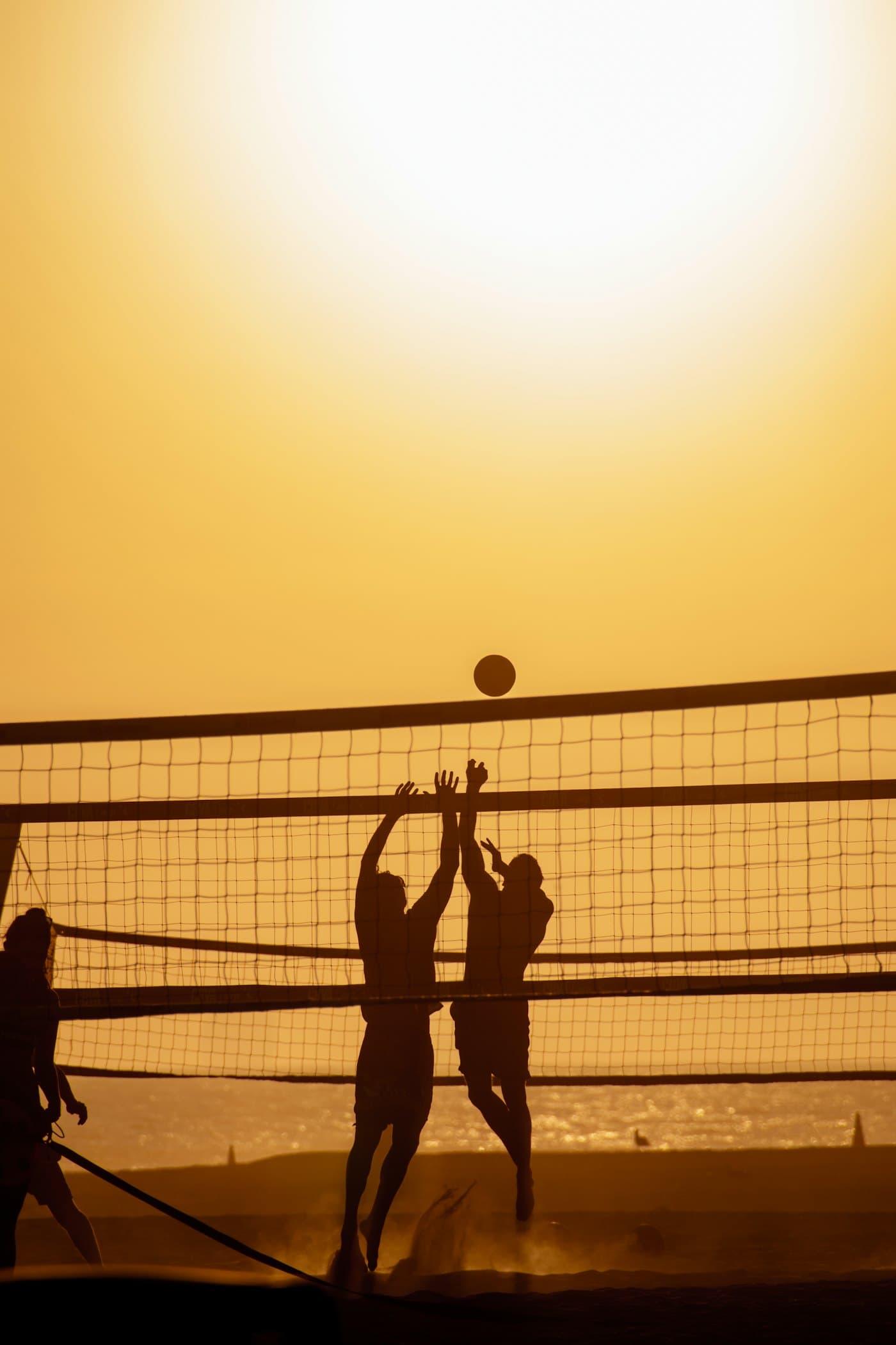 Volleyball players jumping at the net